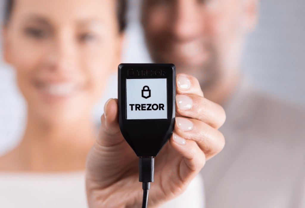 Lady holding up a Trezor cold wallet