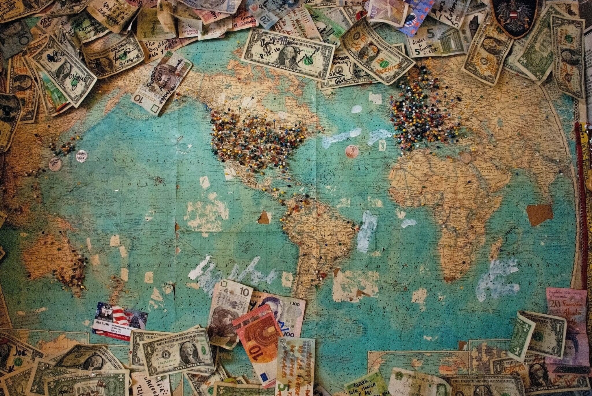 Picture of world map with lots of bank notes on