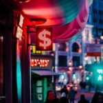 City street at night illuminated by neon dollar sign, symbolising digital wealth, urban finance, and passive income opportunities with NFTs and crypto assets in 2025